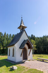 Fototapeta na wymiar Small white chapel in front of the forest edge in the Black Forest. Germany