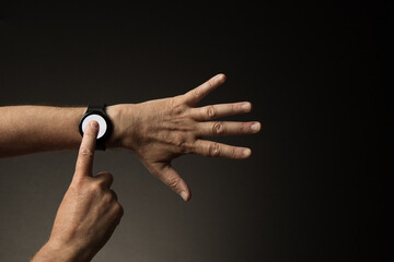 Hand with finger pressing smart watch displaying blank white screen