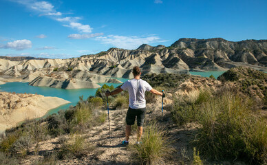 Naklejka na ściany i meble hiker man looking at beautiful turquoise lake and mountain- Andalusia