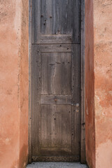 Old vintage wooden door and coral colourful walls. Traditional European old town building. Old historic architecture