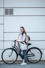 Fototapeta na wymiar happy elegant woman with bicycle outside on city street