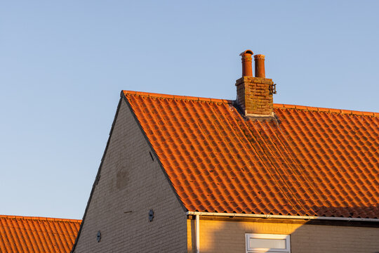 Terracotta clay roof tiles on house with golden hour light