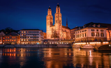 Fototapeta na wymiar Panorama image of evening Zurich. Night long exposure image of the Grossmunster Romanesque-style Protestant church in Zurich, Switzerland. Popular travel dectination.