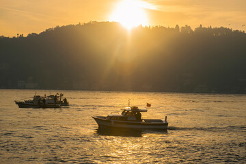 Naklejka premium Men on a boat in Bosphorus waters in Istanbul. Fisherman in boat in Istanbul. Turkish fisherman sailing in boat in sea.