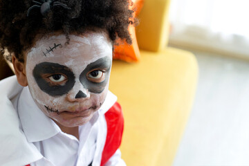 Close up face of African boy dress up as a scary Halloween vampire in a Halloween party, little boy enjoy with his spooky make-up, Halloween celebration concept