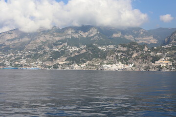 Fototapeta premium Scenic Amalfi Coast view from the sea. Beautiful seascape with yacht near shore in the sea. Modern sailboat on a sunny summer day. Sailing near coastline in the Mediterranean Sea.
