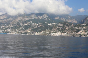 Fototapeta premium Scenic Amalfi Coast view. Beautiful seascape with yacht near shore in the sea. Modern sailboat on a sunny summer day. Sailing near coastline in the Mediterranean Sea.