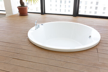 bathroom interior with large windows. white round large bathtub. large windows to the floor
