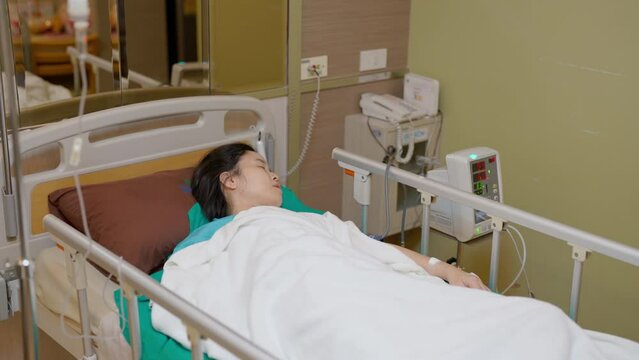 Patient Asia woman on the bed with saline solution and monitor blood pressure at hospital ward room. Treatment emergency recovery after surgery. Hypertension and hypotension. Healthcare and medical