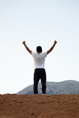 Fototapeta na wymiar young man on a high ground, victory or success concept. selective focus include.