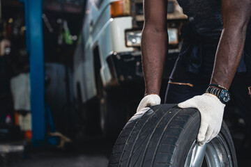 Fototapeta na wymiar Male mechanic wearing gloves checking wheels and tires.