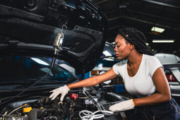 Fototapeta na wymiar Female mechanic wearing gloves checking the engine in the garage.