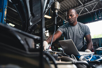 Male mechanic wearing gloves checking the engine in the garage.