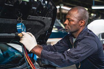Male mechanic checking and maintaining the car air conditioner.