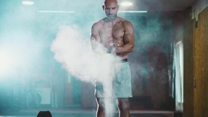 Strongmen athlete hands clapping chalk training in CrossFit gym and lifting a barbell