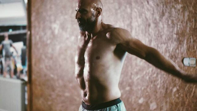 Sweaty bodybuilder cheers himself on and motivates himself for hard work in the gym