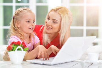 mother and daughter using laptop