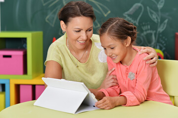 mother and daughter using tablet computer