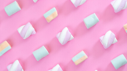 marshmallows on pink background diagonal lines close-up, multi-colored sweets