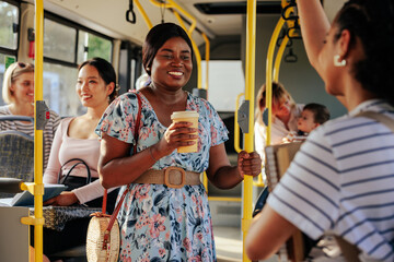 Black woman with coffee to go on bus