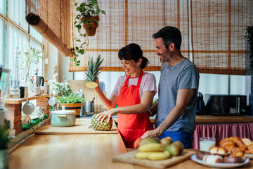 Mid-adult couple in the kitchen preparing food
