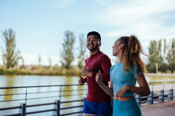 Sporty couple running at riverside