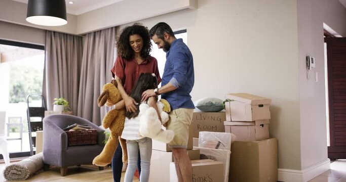 Happy people or family moving into new house with cardboard box. Excited girl smile in a new home, house or apartment. Parent and kid with teddy bear toy in new interior of purchased property