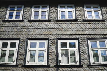 The North German mountains are rich in natural slate resources, which has been mined there. The typical gray house facades are a sign of these rich shale deposits. Goslar, Harz Mountains, Germany.