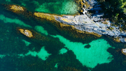 Aerial view of sea waves and fantastic rocky shore. Reefs and algae near the shores of the Norwegian Sea. Norway