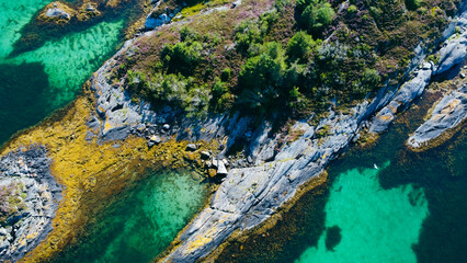 Aerial view of sea waves and fantastic rocky shore. Reefs and algae near the shores of the Norwegian Sea. Norway