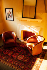 two leather arm chairs in front of fireplace in lobby area of building