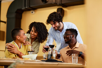 A Group of friends is toasting in a restaurant during dinner.