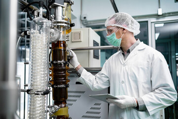 Scientists discover the use of CBD hemp oil in the laboratory. A medical or research scientist or a doctor using a test tube look at a clear solution in a laboratory or laboratory. medical cannabis