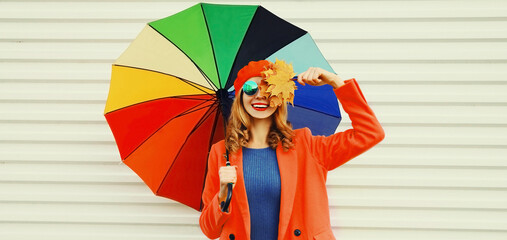 Autumn portrait of happy cheerful smiling young woman with colorful umbrella and yellow maple...