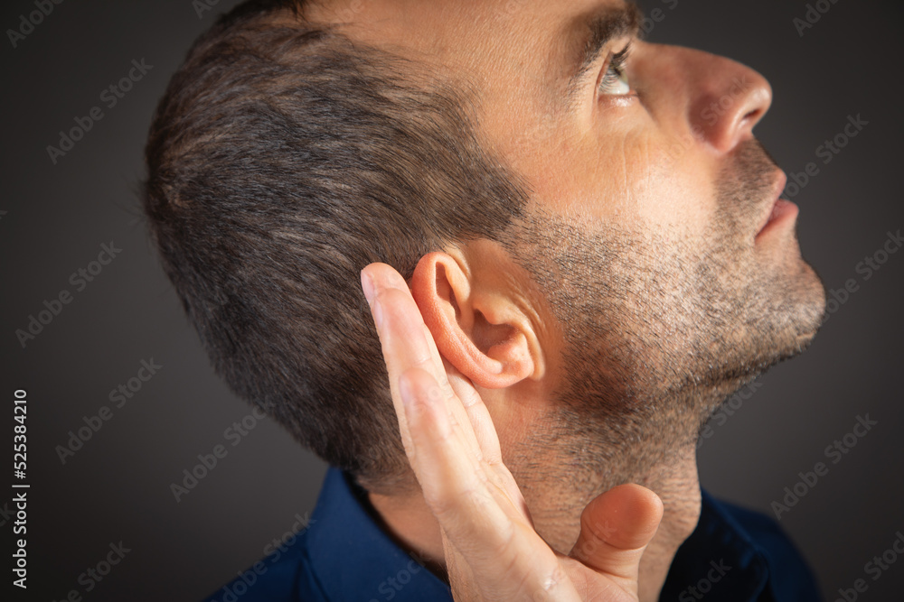 Wall mural caucasian man hold hand near ear. trying to hear a gossip