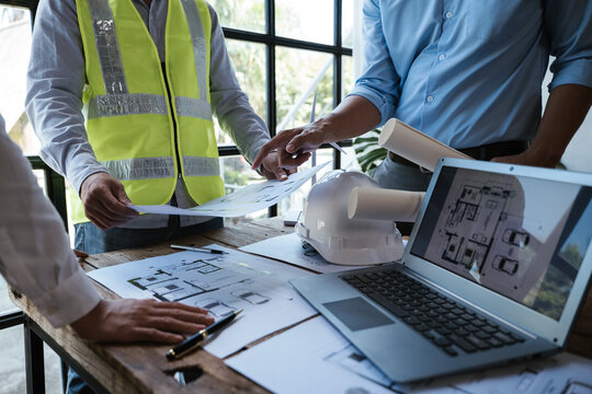Close up of hands working and brainstorming on paperworks and floor plan drawings about design architectural and engineering for houses and buildings.