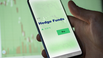 Hedge funds etf fund on screen. A phone shows the ETF's prices of hedge funds to invest, an investor's analyzing.