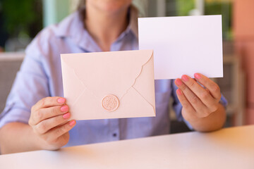 Anonymous woman holding in her hands tender certificate gift and blank card with copy space.