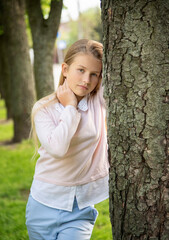 portrait of a little  beautiful  girl with long blond hair in the green park on sunny spring day