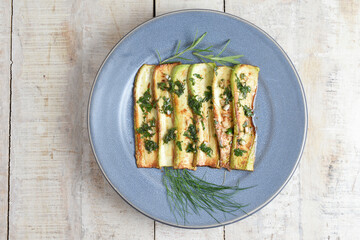 Fried zucchini on plate over wooden background with free text space. Top view flat lay