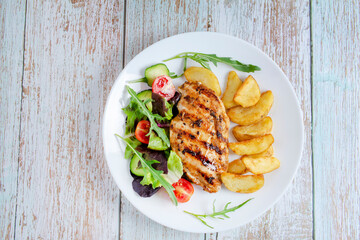 Grilled chicken breast, fillet, steak, fresh vegetable salad and potatoes. top view, copy space. Healthy keto, ketogenic lunch menu with chicken meat and organic veggies and greens. Copy space