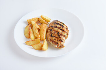 Tasty grilled chicken fillets on white plate with potatoes. Isolated on white background, top view