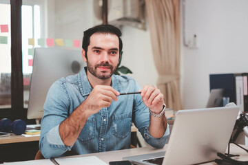 Fototapeta premium Young businessman with digital laptop in office. Cheerful casual caucasian employee. Portrait of confident modern young businessman hand holding digital tablet.
