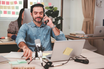 Portrait of smiling businessman with laptop sitting at desk in office. Cheerful casual caucasian employee, Handsome businessman using mobile phone. successful business working at office. mobile phone.