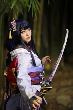 Portrait of a beautiful young woman game cosplay with samurai dress costume on Japanese garden