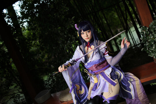 Portrait of a beautiful young woman game cosplay with samurai dress costume on Japanese garden