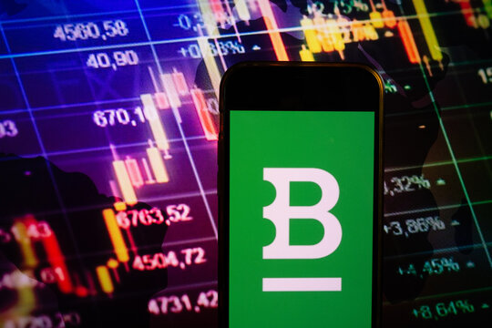 KONSKIE, POLAND - August 10, 2022: Smartphone displaying logo of Bitstamp cryptocurrency exchange on stock exchange chart background