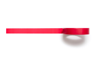 A coil of red electrical tape is unwound and glued to a white background. Tool for insulating wiring in electrical systems during repairs. Insulating tape for electrical work during construction