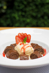 Chocolate pancakes crepe with ice cream and strawberries