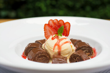 Chocolate pancakes crepe with ice cream and strawberries
